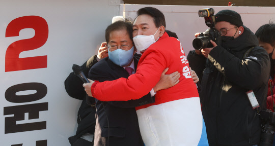 윤석열(가운데 오른쪽) 국민의힘 대선후보가 15일 오후 대구 동구 동대구역 광장에서 열린 거점 유세에서 지지 연설을 마친 옛 경선 최대경쟁자 홍준표(가운데 왼쪽) 선거대책본부 상임고문과 포옹하고 있다.<공동취재·연합뉴스>